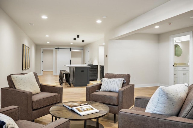 living room featuring a barn door and light hardwood / wood-style floors