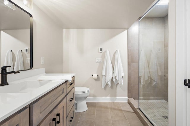 bathroom with tile patterned floors, vanity, toilet, and a shower with shower door