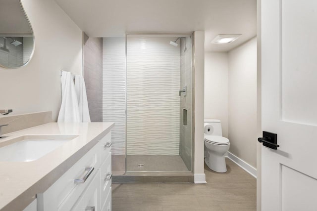 bathroom featuring vanity, toilet, and a shower with shower door