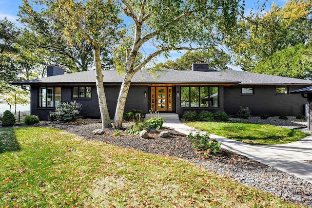 2291 Williams Point Dr, Stoughton, WI 53589 - view of front of house with a chimney, a front lawn, and brick siding