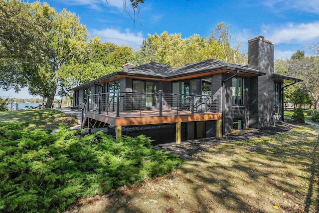 rear view of house featuring a wooden deck and a yard