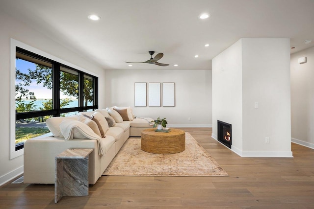 living room with light hardwood / wood-style floors and ceiling fan