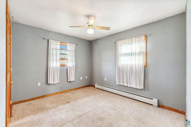 carpeted empty room with plenty of natural light, ceiling fan, and baseboard heating