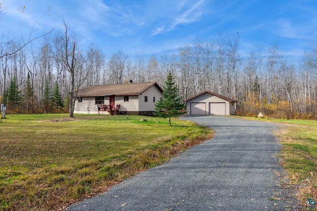 single story home featuring a front yard, an outbuilding, and a garage