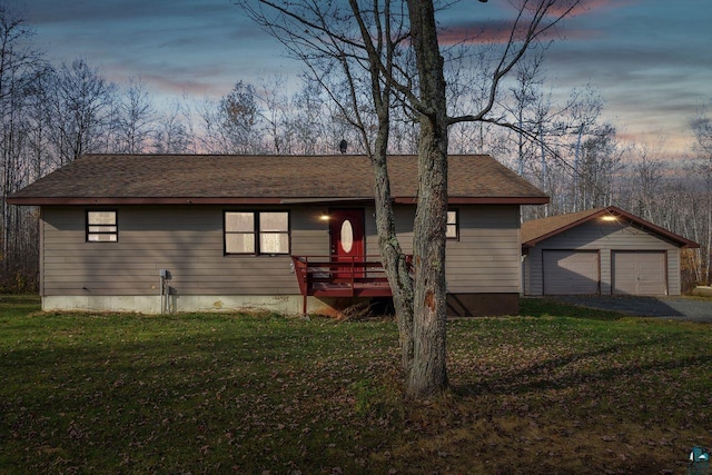 view of front of house with a yard, a deck, an outbuilding, and a garage