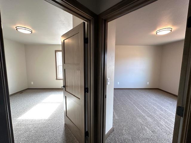 unfurnished room featuring baseboards and carpet floors