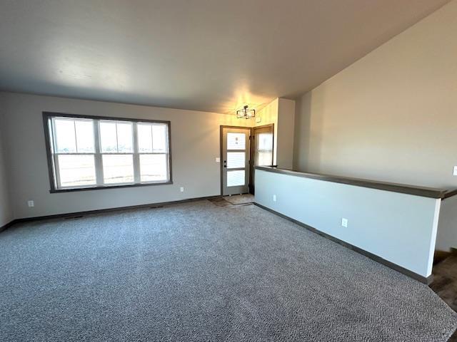 unfurnished room featuring lofted ceiling, baseboards, and carpet floors