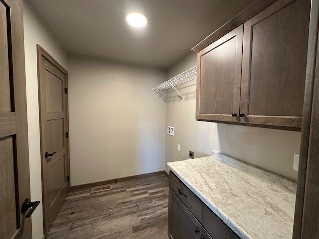 laundry room with electric dryer hookup, dark wood-style floors, cabinet space, baseboards, and hookup for a washing machine