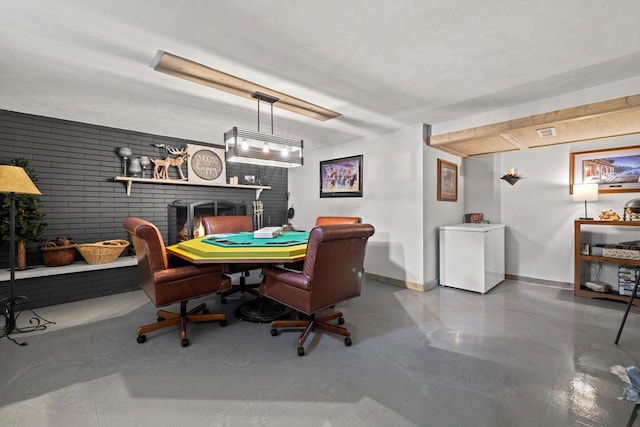 dining area featuring brick wall, concrete flooring, and a fireplace