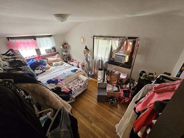 bedroom featuring vaulted ceiling, cooling unit, and wood-type flooring