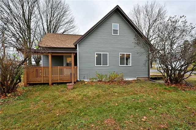 back of property with a wooden deck and a lawn