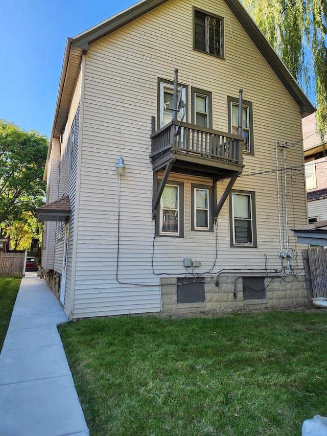 back of property featuring a yard and a balcony