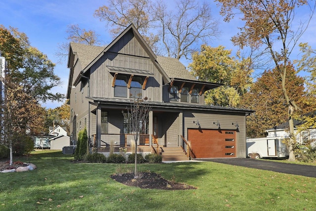 view of front facade with covered porch, a front yard, and a garage