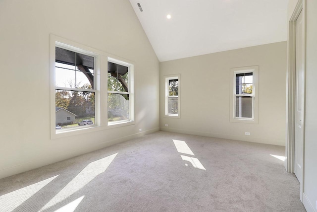 empty room featuring light carpet and high vaulted ceiling