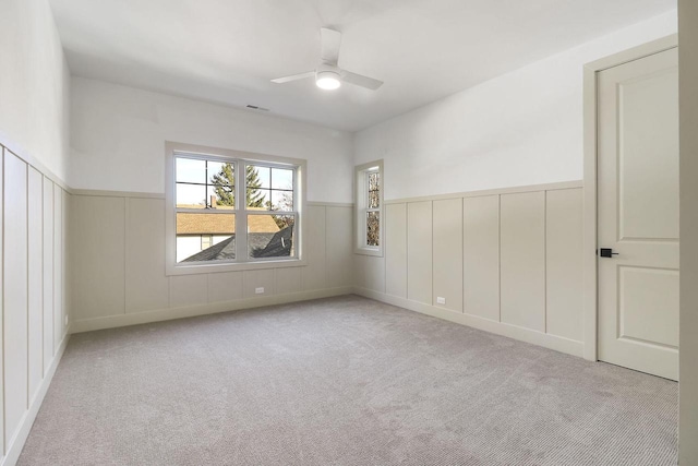 carpeted spare room featuring ceiling fan