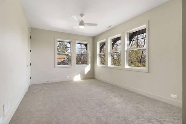 spare room featuring light colored carpet and ceiling fan