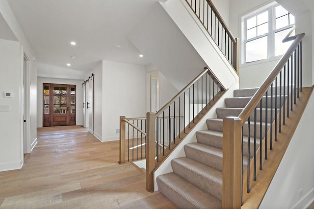 staircase featuring a barn door and hardwood / wood-style flooring