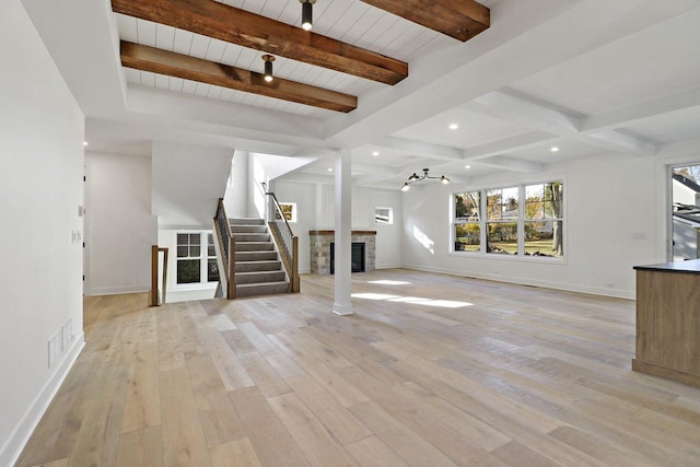 unfurnished living room featuring light hardwood / wood-style floors and beamed ceiling