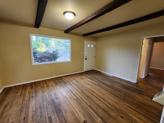 interior space featuring dark wood-type flooring, wood walls, and beamed ceiling