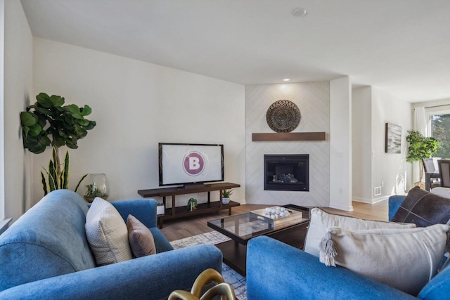 living room with light hardwood / wood-style floors and a large fireplace