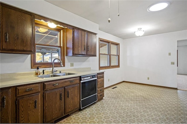 kitchen featuring dishwasher, sink, and dark brown cabinets