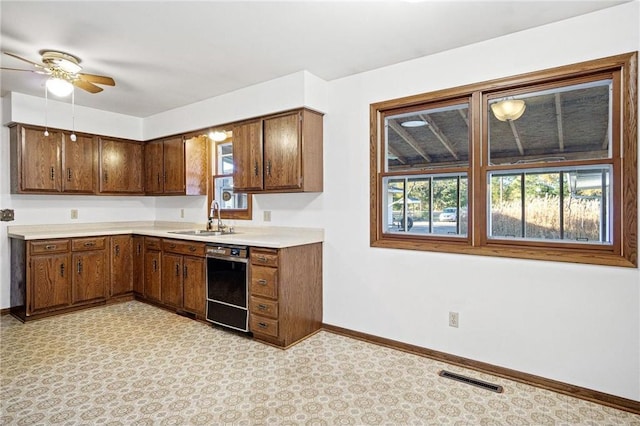 kitchen with black dishwasher, sink, and ceiling fan