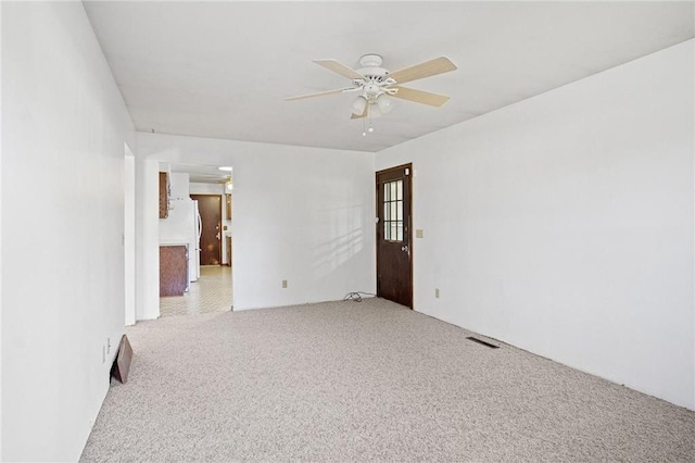 spare room with ceiling fan and light colored carpet