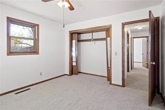 unfurnished bedroom with light carpet, a closet, and ceiling fan