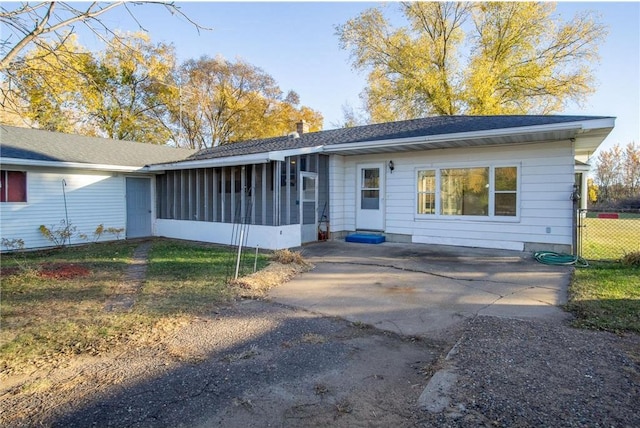 rear view of house with a patio and a sunroom