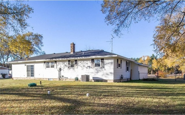 rear view of property with a lawn and central AC unit