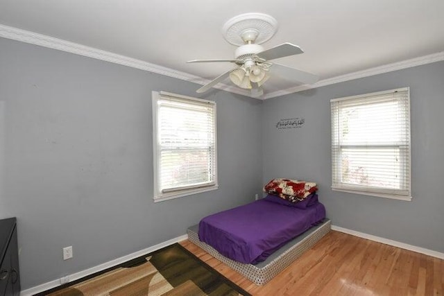 bedroom with ornamental molding, hardwood / wood-style floors, and ceiling fan