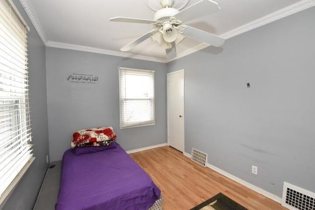 bedroom with hardwood / wood-style floors, crown molding, and ceiling fan