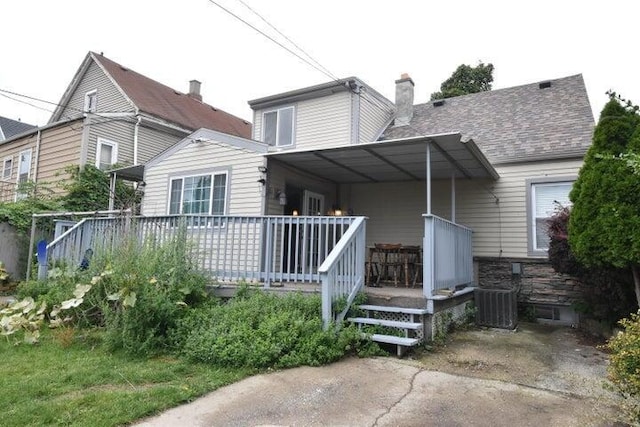 back of house with a porch, cooling unit, and a carport