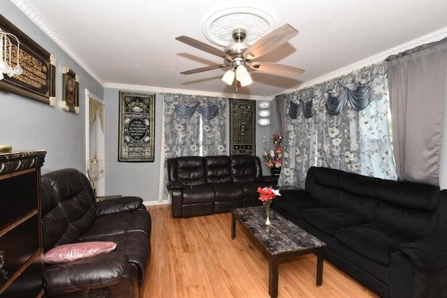 living room with crown molding, hardwood / wood-style flooring, a fireplace, and ceiling fan