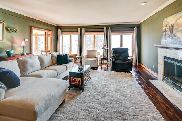 living room featuring ornamental molding, a fireplace, a wealth of natural light, and hardwood / wood-style flooring