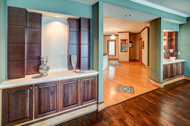 hall with baseboard heating, hardwood / wood-style flooring, and ornamental molding