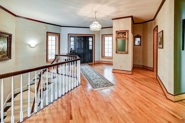 foyer featuring ornamental molding, hardwood / wood-style floors, and a wealth of natural light