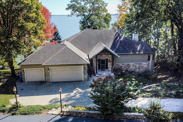 view of front of property with a garage and a water view