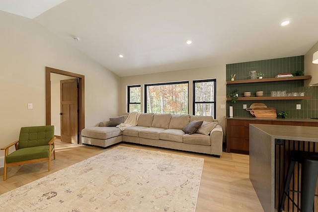 living room featuring lofted ceiling and light wood-type flooring