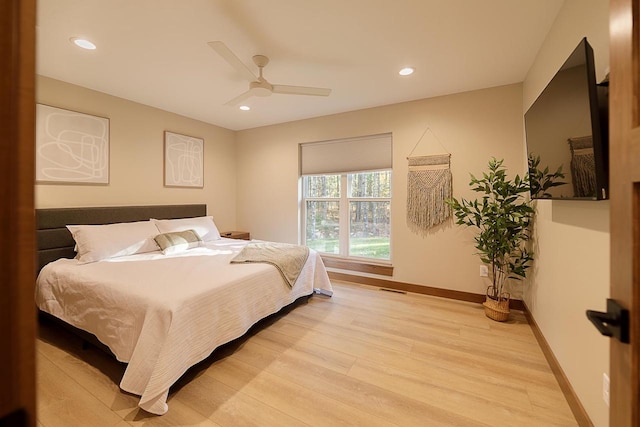 bedroom with light hardwood / wood-style floors and ceiling fan