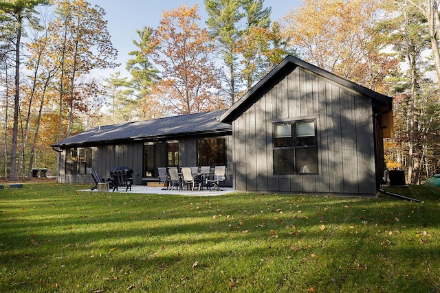 back of house with a patio area and a lawn