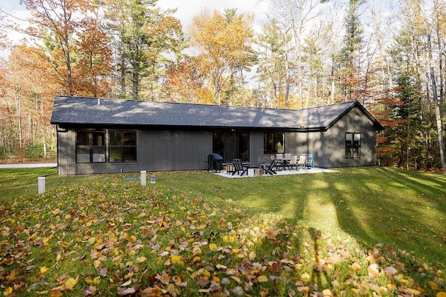 back of property with a yard and a patio