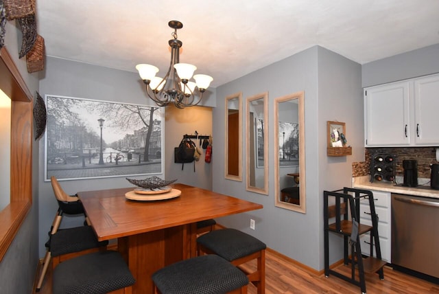 dining room with light hardwood / wood-style flooring and a chandelier