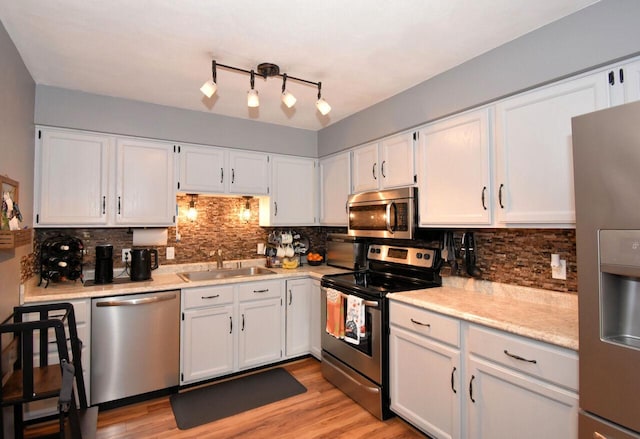 kitchen featuring sink, appliances with stainless steel finishes, and white cabinetry