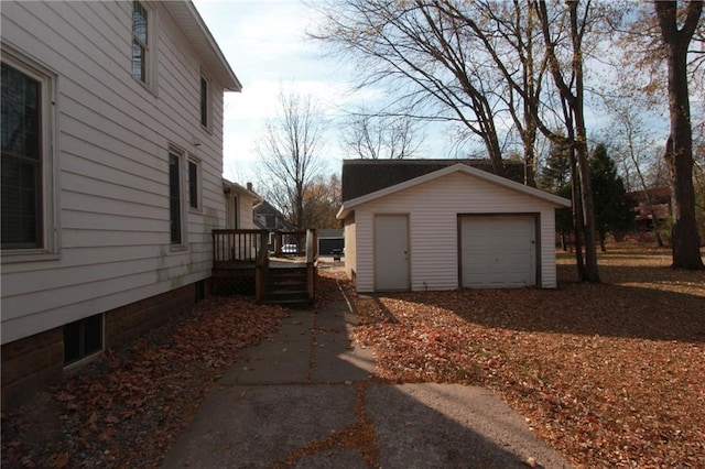 view of side of property featuring an outdoor structure, a deck, and a garage