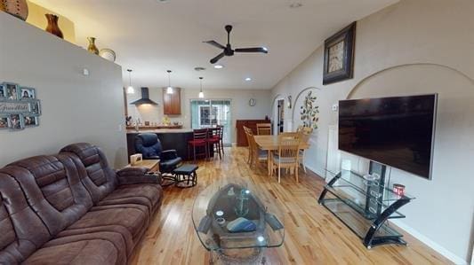 living room with ceiling fan and light hardwood / wood-style flooring