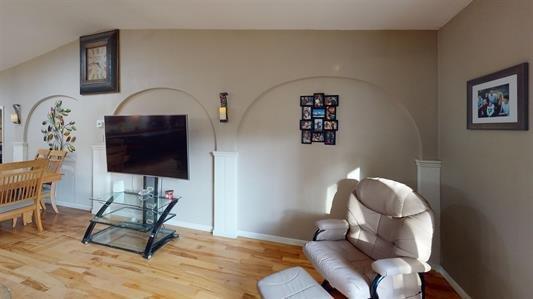 living area with wood-type flooring and lofted ceiling