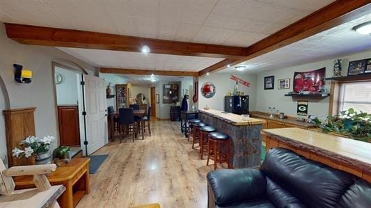 bar featuring beamed ceiling and light hardwood / wood-style floors