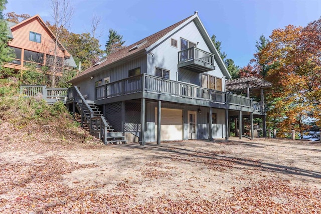 rear view of property featuring a pergola and a wooden deck