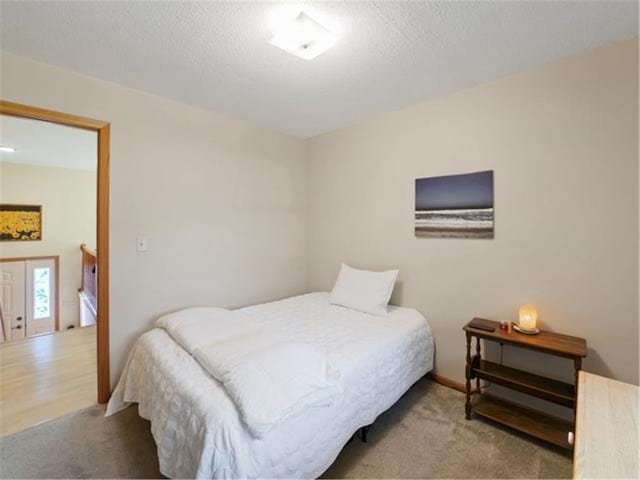 bedroom with light carpet and a textured ceiling